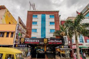 a building with a sign in the middle of a street at Capital O 5381 The Emirates Hotel in Bangalore