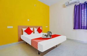 a bedroom with a bed with red pillows at OYO Flagship Hotel Mint Residency in New Delhi