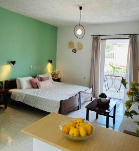 a bedroom with a bed and a bowl of fruit on a table at Rodakino Βay in Rodakino