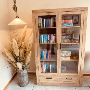 una estantería de madera con libros. en Stylisches modernes Apartment, Sauna und Wellness Top Lage, en Lübbecke