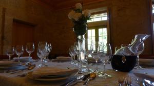 a table with wine glasses and a vase with flowers at Casa de Ladreda in Tangil