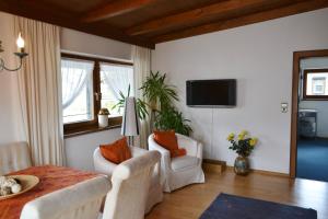 un soggiorno con mobili bianchi e TV di Appartementhaus Astl a Sankt Johann in Tirol