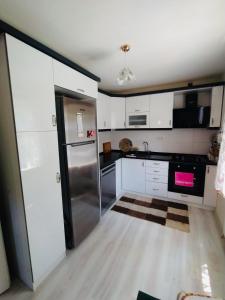 a kitchen with white cabinets and a stainless steel refrigerator at ASYA HOME in Kocaeli