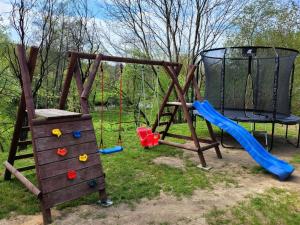 um parque infantil com um baloiço e um escorrega em DomEK Obok Rzeki em Bałtów