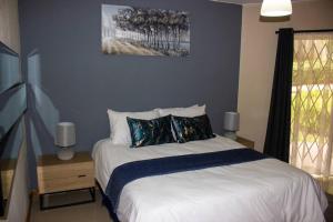 um quarto com uma cama grande e paredes azuis em A homely and secure 2 bedroom with uncapped Wifi em Joanesburgo