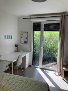 Schlafzimmer mit einem Bett, einem Schreibtisch und einem Fenster in der Unterkunft ** Studio cosy La Rochelle quartier des Minimes ** in La Rochelle