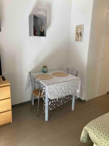 een witte tafel met stoelen en een tv in een kamer bij ** Studio cosy La Rochelle quartier des Minimes ** in La Rochelle