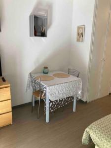 einen weißen Tisch mit Stühlen und einen TV in einem Zimmer in der Unterkunft ** Studio cosy La Rochelle quartier des Minimes ** in La Rochelle