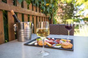 een tafel met een bord eten en twee glazen wijn bij Hôtel Parc Adélie - Logis Hôtels in Montagny-lès-Beaune