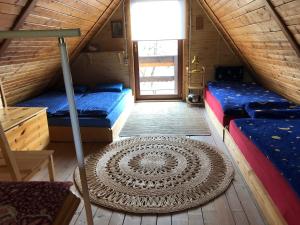 a room with two beds and a rug in a cabin at Domek Jakusówka Laliki Pochodzita w sercu Beskidów in Laliki +31 photos