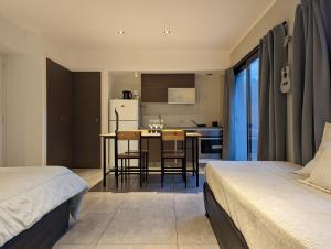 1 dormitorio con 2 camas y cocina con mesa en Hedonism apartments en Mar del Plata