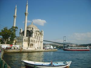 een gebouw met twee torens op het water met twee boten bij Cozy Garden Flat by SUMMITVISTA in Istanbul