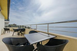 a balcony with a table and chairs and the ocean at MonteCasa Seaview Rooms in Dobra Voda