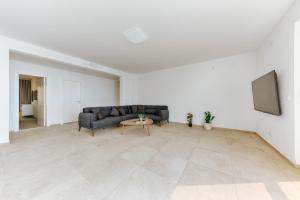 a living room with a couch and a tv at MonteCasa Seaview Rooms in Dobra Voda
