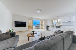 a living room with a couch and a table at MonteCasa Seaview Rooms in Dobra Voda