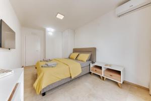 a bedroom with a bed with a yellow blanket at MonteCasa Seaview Rooms in Dobra Voda