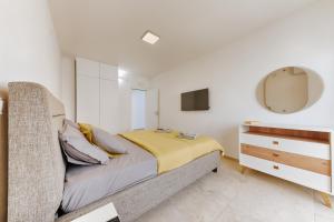 a bedroom with a bed and a dresser and a mirror at MonteCasa Seaview Rooms in Dobra Voda
