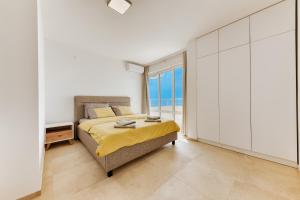 a bedroom with a bed and a view of the ocean at MonteCasa Seaview Rooms in Dobra Voda