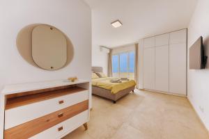 a bedroom with a bed and a mirror on the wall at MonteCasa Seaview Rooms in Dobra Voda