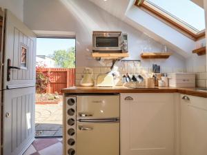 a kitchen with a counter with a microwave above it at Admiral Cottage in Woodbridge