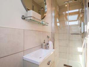 a white bathroom with a sink and a shower at Admiral Cottage in Woodbridge +19 photos
