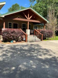 a house with a porch and a fence at The Manor- 4 BR Home with Pool Table, Swimming Pond and Sand Volleyball in Montgomery