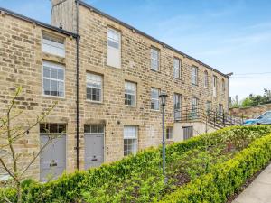 a brick building with white doors and windows at The Mill Townhouse in Pateley Bridge