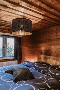 a bedroom with a large bed in a room with wooden walls at Cosy and Romantic forest house op de Veluwe in Putten