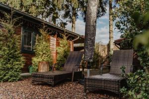 two wicker chairs sitting in front of a house at Cosy and Romantic forest house op de Veluwe in Putten