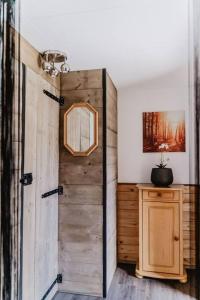 a wooden door in a room with a mirror at Cosy and Romantic forest house op de Veluwe in Putten