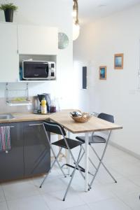 een keuken met een houten tafel en 2 stoelen bij Le Porge Beach House - 4 people in Le Porge