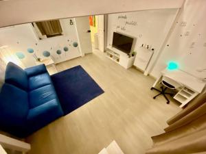 un soggiorno con divano blu e TV di la Piccola Dimora appartamento a Taranto