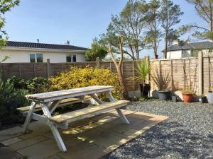 a wooden picnic bench sitting in a yard at Orchard Cottage, Pwllheli, North Wales in Pwllheli