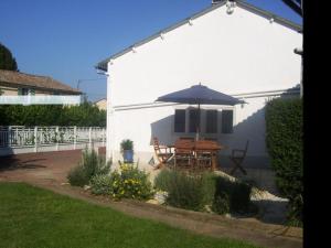 un patio con mesa y sombrilla en Lovely 4-Bed House in rural West France, en Clussais-la-Pommeraie