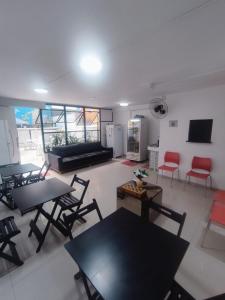 ein Wohnzimmer mit Tischen, Stühlen und einem Sofa in der Unterkunft Hostel Princess Copacabana in Rio de Janeiro