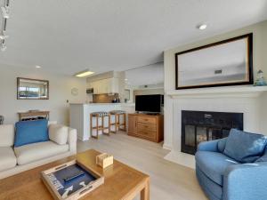 a living room with a tv above a fireplace at 226 Edgewater Inn in Charlevoix
