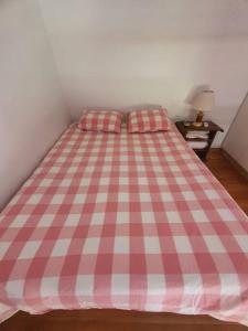 1 cama rosa y blanca con 2 almohadas en Luminoso Loft, bien distribuido en Balvanera. Viamonte y Ayacucho en Buenos Aires