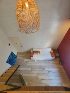 Habitación con cama, lámpara de araña y escaleras. en Luminoso Loft, bien distribuido en Balvanera. Viamonte y Ayacucho en Buenos Aires