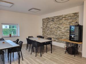 a room with tables and chairs and a brick wall at HOSTEL Postaja in Ruše