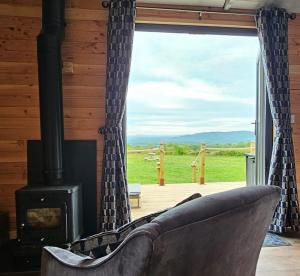 sala de estar con sofá y chimenea en Wye Valley Cabin, en Upper Welson