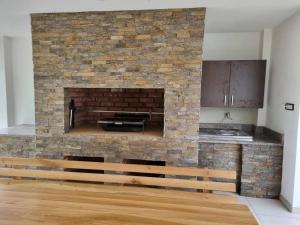 a brick fireplace in a kitchen with a wooden bench at Drinska Magija in Loznica