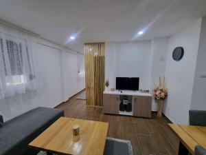 uma sala de estar com uma televisão, um sofá e uma mesa em Drinska prica 2 em Loznica