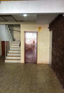 un pasillo vacío con una puerta marrón y escaleras en SOL Y PLAYA STA en Santa Teresita