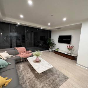 sala de estar con sofá y TV en Carlton Stunning View Apartment with Free Parking -2 en Melbourne