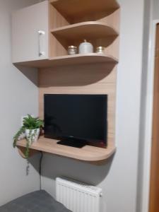 a flat screen tv sitting on a shelf in a room at Golden Sands Retreat in Mablethorpe
