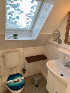 a bathroom with a window and a toilet and a sink at Haus Kaiser Ferienwohnung und Appartementvermietung in Büsum +59 photos