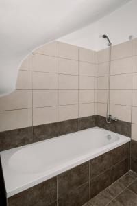 y baño con bañera y pared de azulejos. en Mandi's Apartments, en Karavádhos
