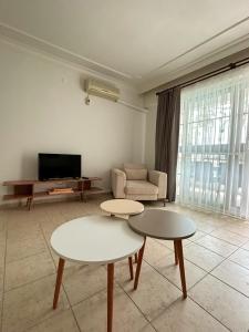 a living room with two tables and a tv at Somos Flats in Didim