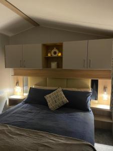 a bedroom with a large bed with a wooden headboard at Golden Sands Retreat in Mablethorpe