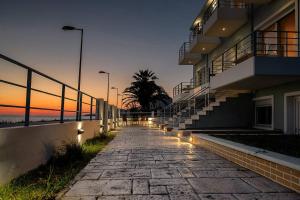 a stone walkway next to a building with lights at Privilegio Studio 4 in Kanali +6 photos
